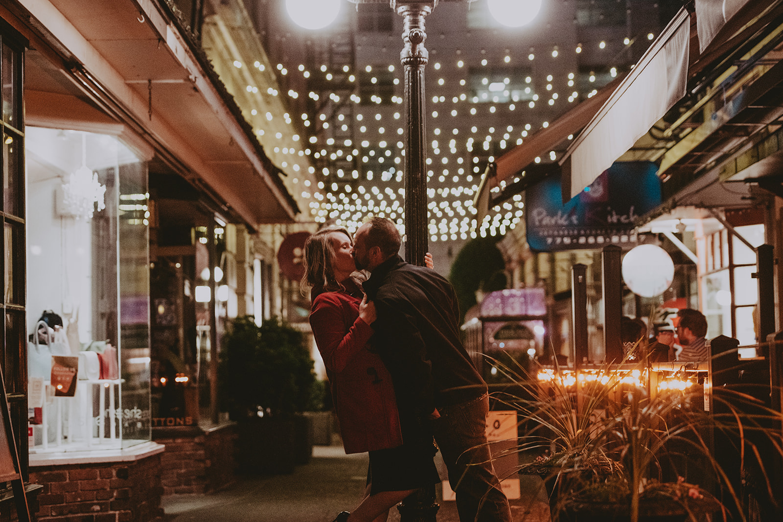 Engagement photoshoot. Couple kissing in a romantic setting in an alley